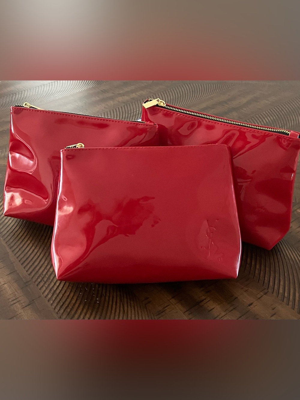Three Yves Saint Laurent Beaute cosmetic bags red patent with embossed logo